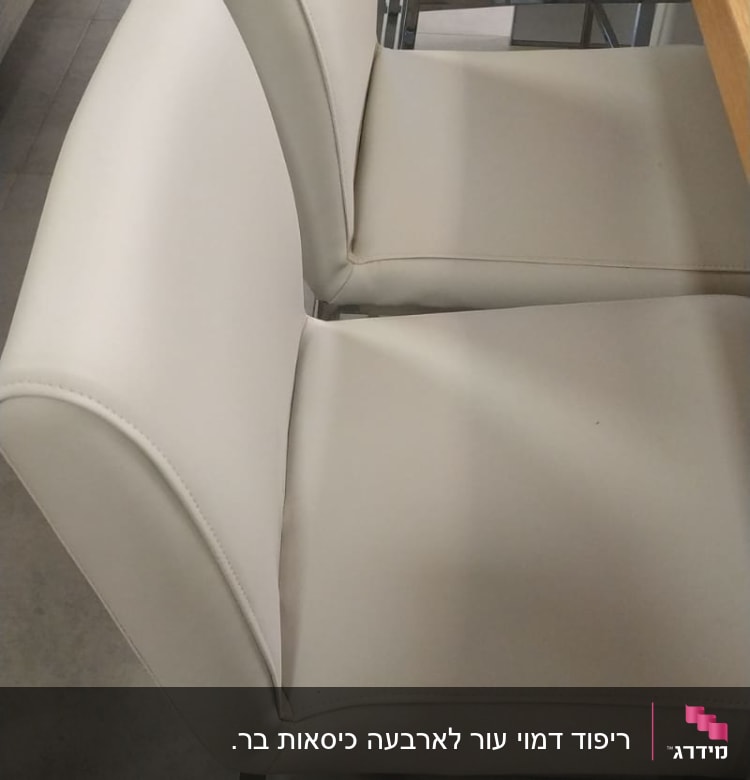 כיסאות מרופדים בלבן ליד שולחן עץ